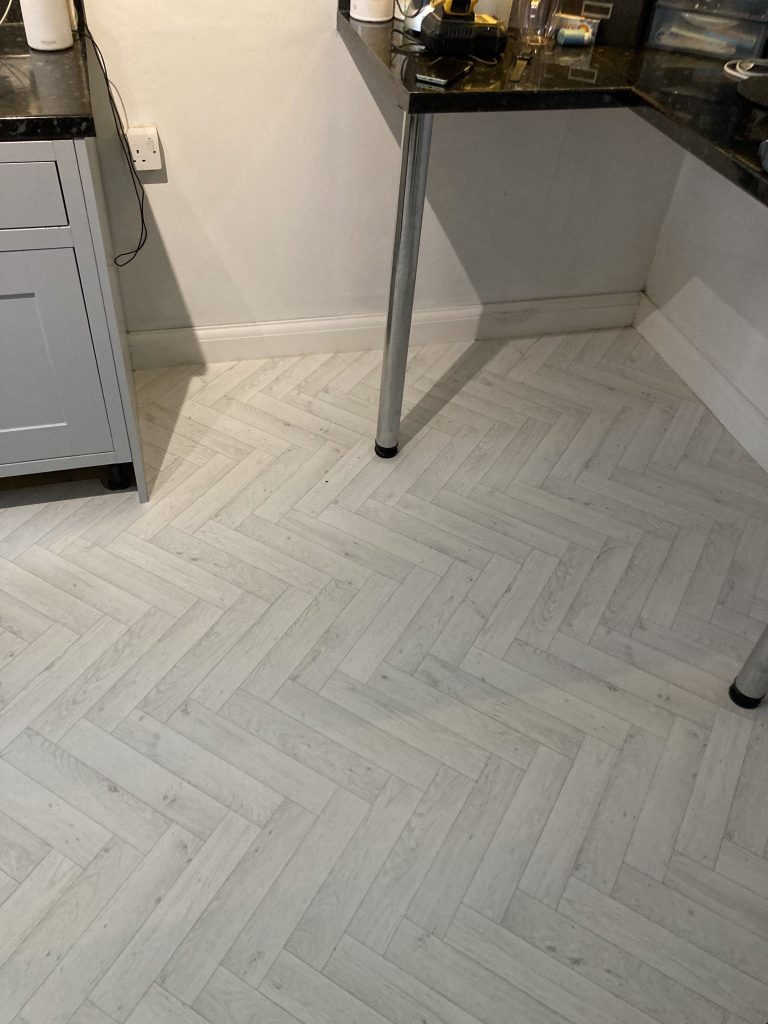 Light grey herringbone vinyl professionally fitted in a kitchen