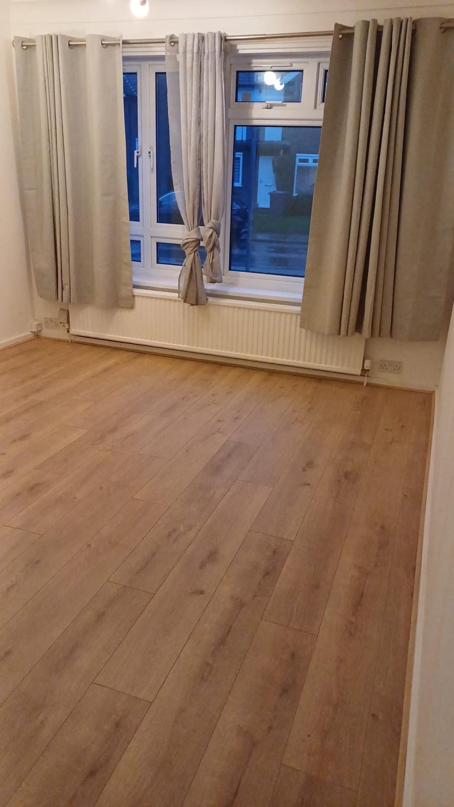 Laminate flooring fitted throughout a residential room by Strictly Floors